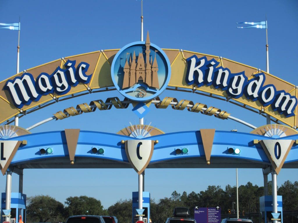 A sign for the magic kingdom in front of cinderella castle.