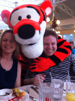 A man and woman posing with a stuffed tiger.