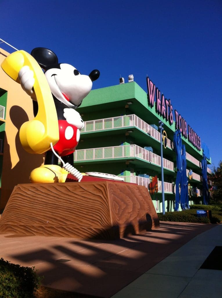 A large statue of mickey mouse and pluto in front of the walt disney world resort.