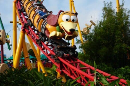 A close up of a roller coaster with people riding it